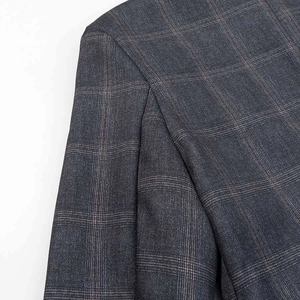 Detail of the high-quality gray check blazer showing fabric texture and shoulder seams