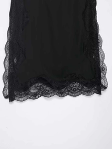 Detailed view of the elegant black lace trim on the hem of a stylish camisole top