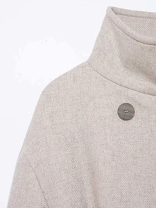 Close-up of wool coat collar with refined texture and premium dark round button detail