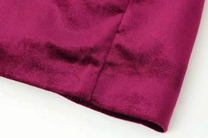 Close-up of deep burgundy velvet fabric showing fine texture and meticulous stitching details
