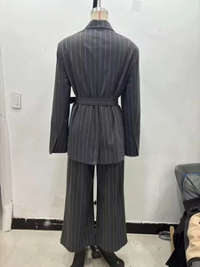Back view of dark grey pinstripe blazer suit with belted waist and wide-leg trousers