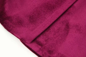 Macro shot of premium dark magenta velvet fabric showing soft texture and glossy sheen