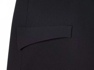 Detailed macro view of the pocket stitching and fine woven texture on a black dress
