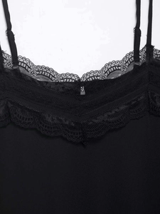 Detailed close-up of a black camisole featuring delicate eyelash lace trim and adjustable straps