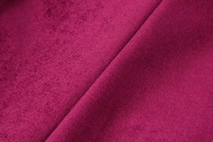 Detailed close-up of dark rose red velvet fabric with soft texture and natural drapes