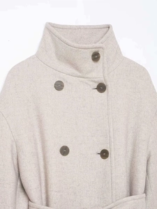 Detailed close-up of double-breasted oat wool coat showing textured fabric and buttons