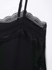 Detail shot of delicate black floral lace trim and smooth fabric on a camisole top