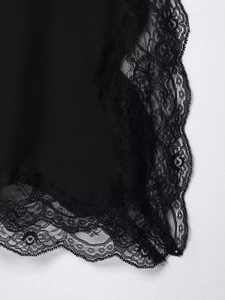Detailed view of black silk-like fabric with intricate floral lace trim and scalloped edges