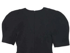 Detail of black puff sleeve dress featuring a round neck and hidden back zipper