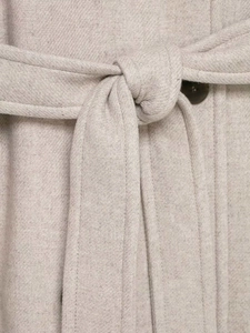 Close-up of beige wool coat with twill texture, waist belt tie and resin button detail
