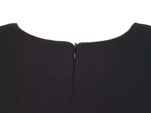 Macro view of a black puff sleeve dress showing the round neckline and invisible zipper detail