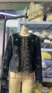Détails de la veste en velours noir avec broderies dorées et sequins étincelants
