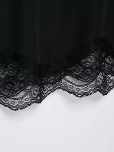 Detailed macro view of black plain fabric featuring delicate floral hollow lace trim on edges