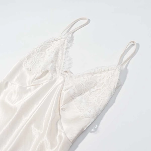Elegant white satin slip dress with lace embroidery and slim straps in a clean flat lay view