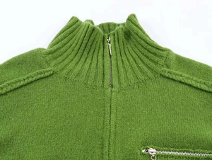 Detail of green ribbed knit cardigan with high collar and metal zip pocket texture