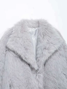 Dettaglio di un cappotto in ecopelliccia grigio chiaro con ampio risvolto e fodera in raso