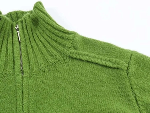 Detailed macro view of the ribbed knit texture and half-zipper collar on this green sweater