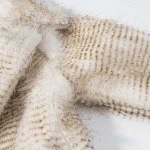 Detailed macro view of soft faux fur texture with apricot and brown striped pattern