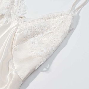 Close-up of white lace trim with eyelash edges on elegant satin dress bodice