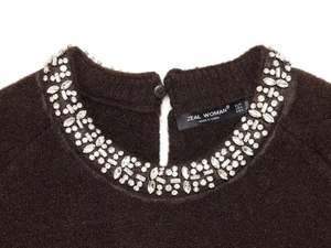 Close-up of brown knit cardigan featuring a sparkling rhinestone-embellished round collar