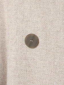Macro shot of oat beige wool blend fabric texture with dark brown resin button detail