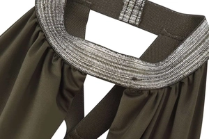 Detail of dark olive green pleated fabric with silver metallic chain neck strap