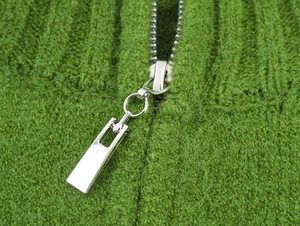Close-up of grass green knit cardigan featuring high-quality silver metal zipper detail