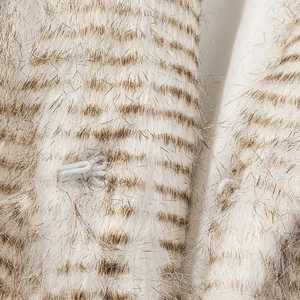 Macro view of apricot striped faux fur coat showing hidden hook-and-eye closure detail