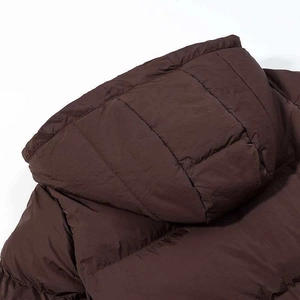 Close-up of brown hooded puffer jacket featuring horizontal quilting and windproof fabric