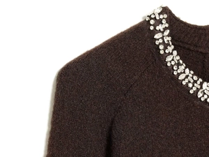 Detailed macro view of dark brown knit cardigan featuring luxury rhinestone collar embellishment