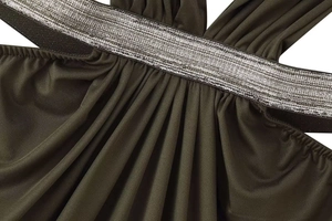 Detail of olive green knit fabric with vertical pleats and silver metallic strap