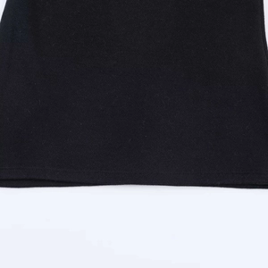 Close-up detail of the black knit fabric texture and hemline of the off-shoulder sweater