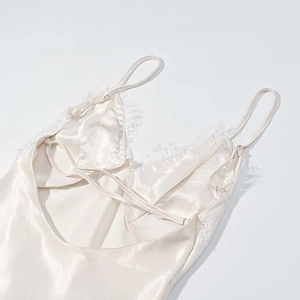 Detail of champagne satin dress with eyelash lace trim and adjustable cross straps