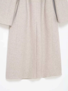 Close-up of oatmeal wool blend coat featuring a clean back vent and premium texture