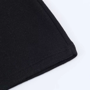 Detailed close-up showing the fine knit texture and high-quality stitching on black sweater