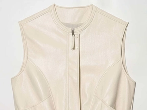 Close-up of matte cream leather vest with silver metal zipper and snap button closure
