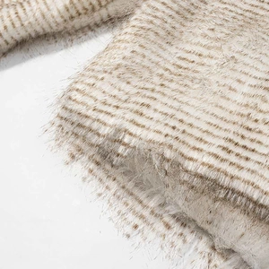 Detailed macro view of the soft beige and brown striped faux fur texture on the winter coat