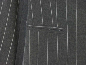Macro shot of welt pocket and white pinstripe texture on dark grey blazer fabric