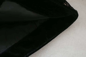Vue détaillée de la texture du velours noir et de la doublure en satin lisse de la veste