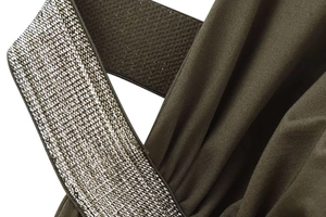 Detail of olive green dress featuring shimmering silver sequin band and pleated fabric