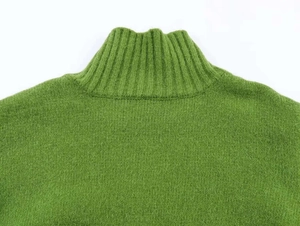 Detail of green ribbed knit cardigan featuring high neck collar and soft texture weave