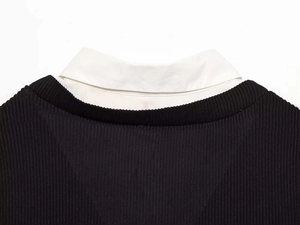 Detail of black ribbed knit top with a white poplin collared shirt insert neckline