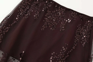 Macro shot of dark purple mesh fabric featuring intricate sequin embroidery and detail