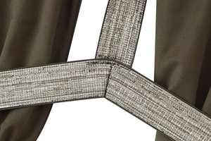 Detail of olive green fabric with silver metallic elastic strap and precise stitching