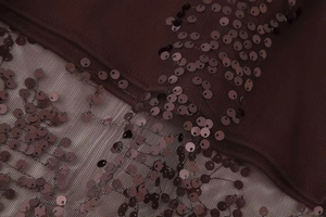 Detailed view of sequin embroidery on burgundy mesh fabric for high-waist skirts