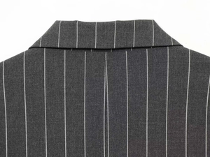 Detailed close-up of charcoal grey pinstripe suit collar and back stitching craftsmanship