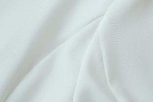 Close-up detail of high-quality white heavy cotton twill fabric showing dense texture