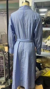 Detail view of a long sleeve blue striped shirt dress with a waist belt and button cuffs