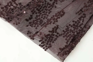 Close-up of deep burgundy sequin embroidery on delicate mesh fabric for elegant skirts
