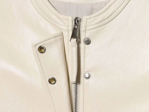 Detail of matte cream faux leather vest featuring round neck and smooth metal zipper closure
